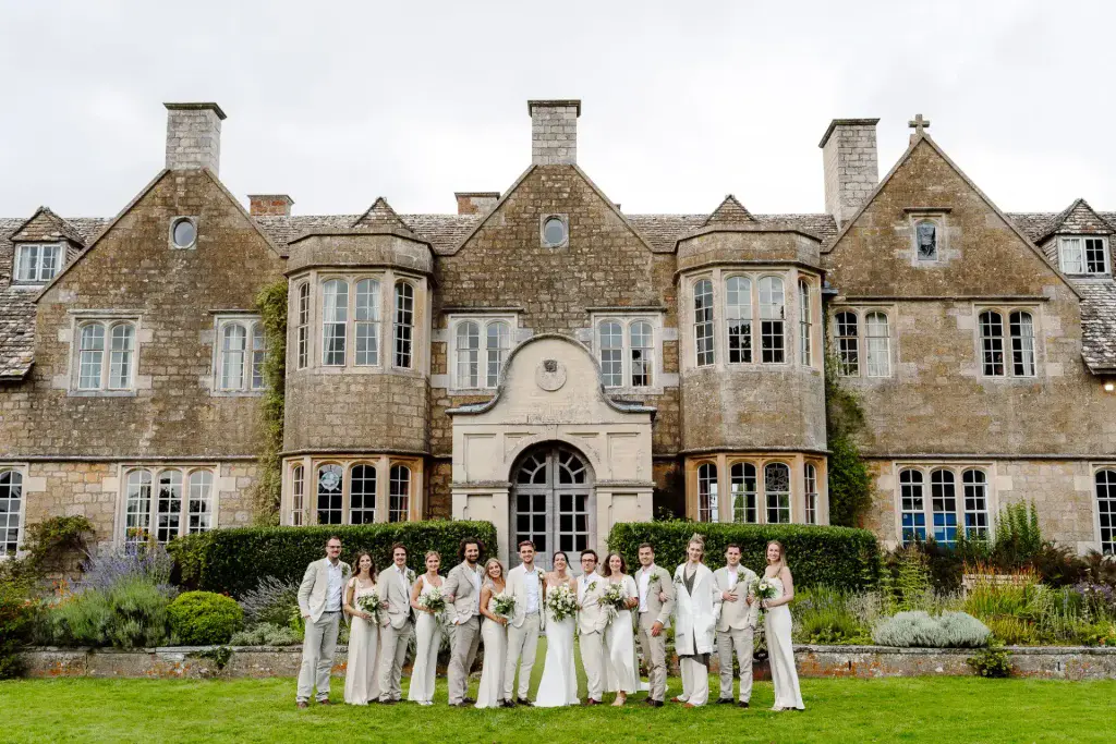 bridal party pose in a line for their cotswold wedding videographer outside hilles house wedding venue