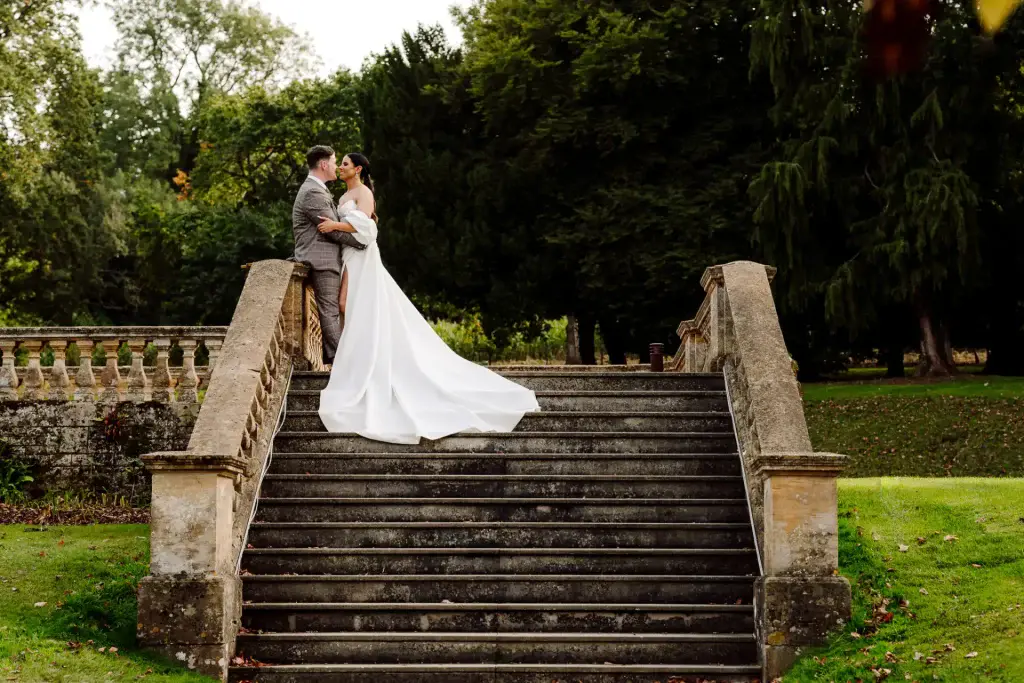 bride and groom kiss on stone steps at coombe lodge wedding venue in somerset
