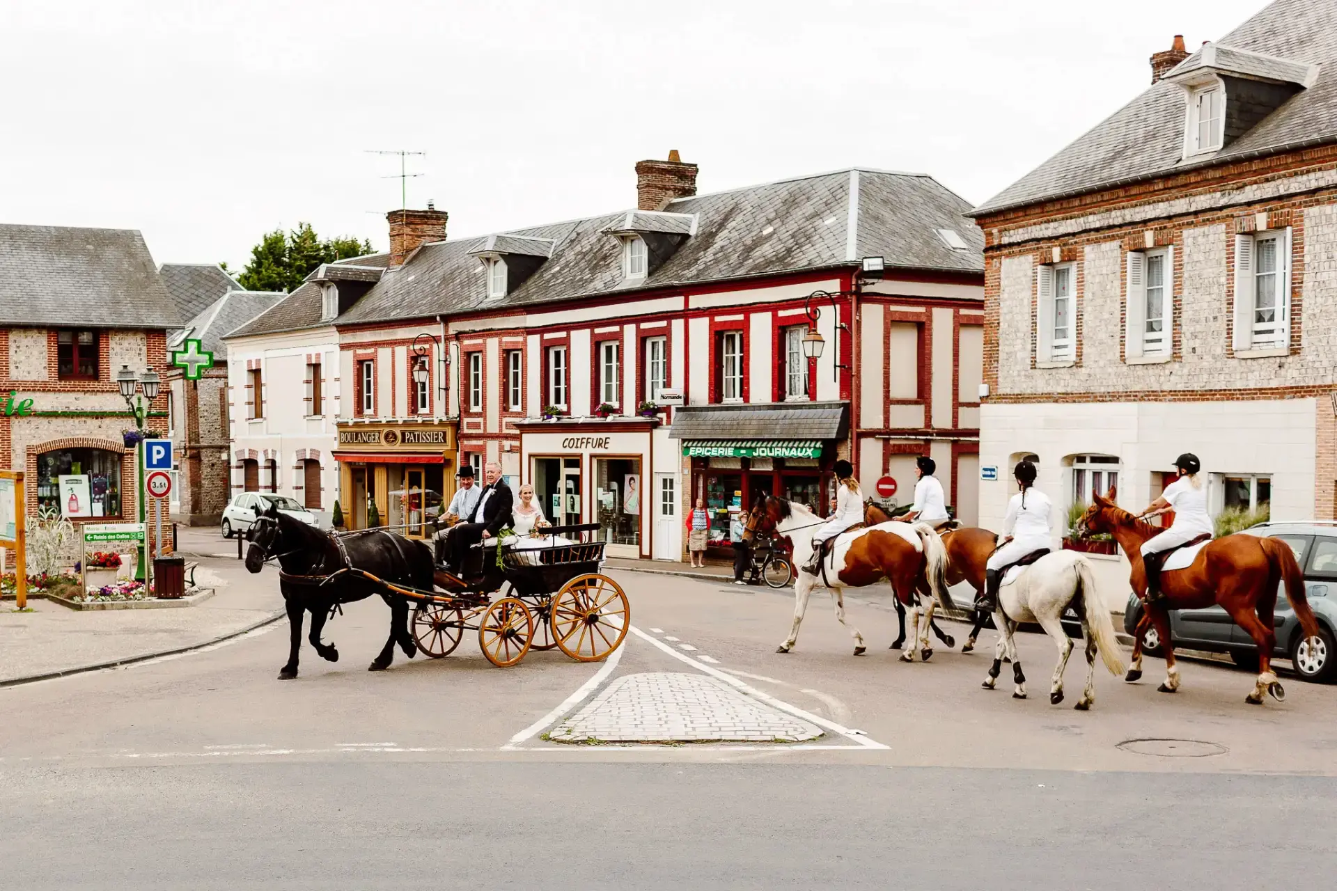 bride and her father riding in a horse and carriage in a small french village street